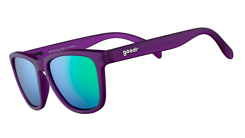 Three-quarter angle view of square-shaped sunglasses with purple frames and reflective green polarised lenses.